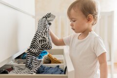 mid-shot-baby-taking-clothes-from-drawer